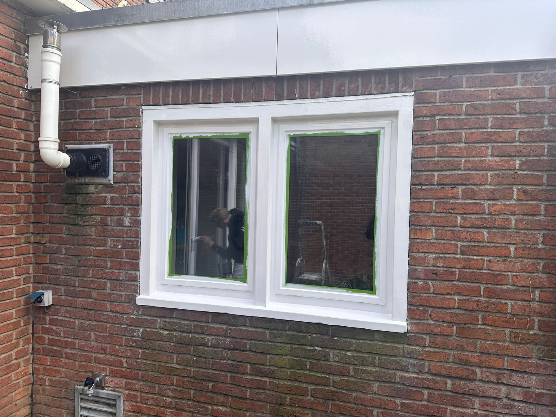 Dubbel raam met strak wit afgewerkt kozijn na het schilderwerk