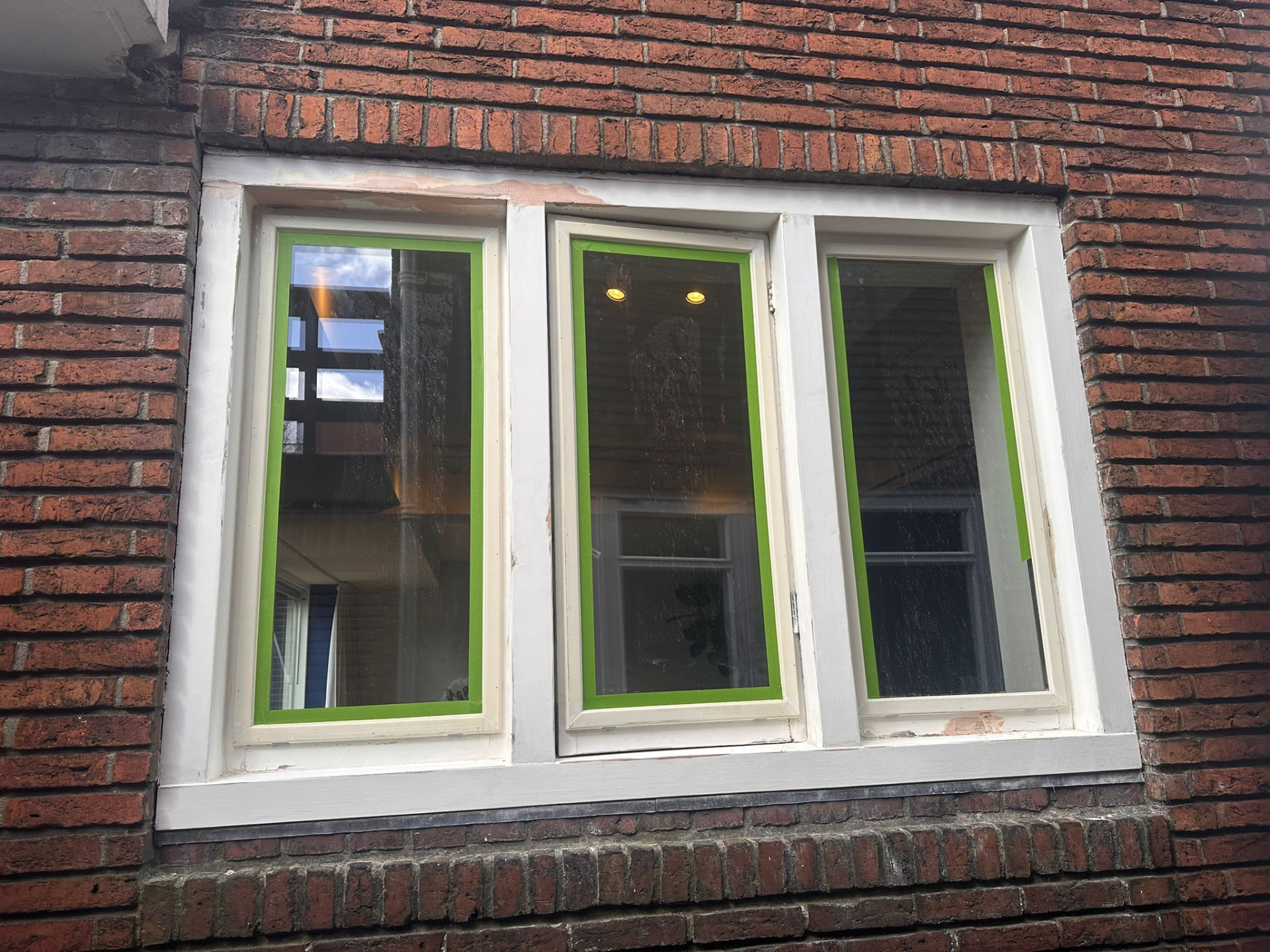 Klassiek drievoudig raam afgeplakt tijdens het schilderwerk