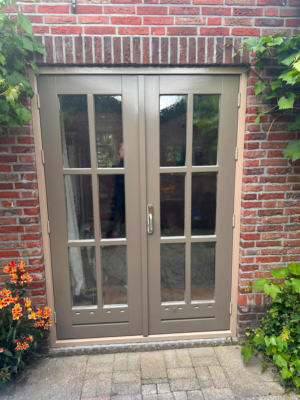 Dezelfde voordeur na het schilderwerk: egaal taupe/bruin geschilderd